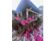 Cozy home featuring a screened porch area and vibrant pink flowers in the front yard at 355 Highland Shores Dr, Ellenton, FL 34222