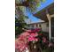 Home exterior surrounded by lush greenery and vibrant pink flowers in a well-maintained yard at 355 Highland Shores Dr, Ellenton, FL 34222