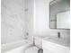 Modern bathroom features marble-look tile, a sleek vanity with sink, and contemporary fixtures at 23113 Brewer Ave, Punta Gorda, FL 33980