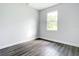 Bright bedroom featuring a window, gray walls, and wood-look flooring at 23113 Brewer Ave, Punta Gorda, FL 33980