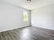 Bedroom with light gray walls, wood-look floors, and bright natural light at 23113 Brewer Ave, Punta Gorda, FL 33980