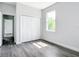 Cozy bedroom with modern floors, window with view, and closet with white bi-fold doors at 23113 Brewer Ave, Punta Gorda, FL 33980