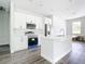 Bright kitchen features white cabinets, stainless steel appliances, island with sink, and wood-look flooring at 23113 Brewer Ave, Punta Gorda, FL 33980