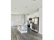 Modern kitchen featuring stainless steel appliances, center island, and wood plank flooring at 23113 Brewer Ave, Punta Gorda, FL 33980