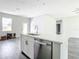 Kitchen island with white quartz countertop, stainless steel dishwasher, and a modern faucet at 23113 Brewer Ave, Punta Gorda, FL 33980