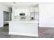 Bright kitchen boasts white cabinets, stainless steel appliances, a center island, and wood-look flooring at 23113 Brewer Ave, Punta Gorda, FL 33980