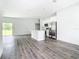 Spacious open floor plan featuring sleek gray wood-look flooring and a stylish kitchen island at 23113 Brewer Ave, Punta Gorda, FL 33980
