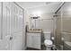 Well-lit bathroom with shower, sink, granite countertop and good storage space behind white doors at 2912 W Frierson W Ave, Tampa, FL 33614