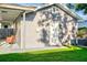 Exterior view of the gray home featuring a white door, well manicured yard, and a covered seating area at 2912 W Frierson W Ave, Tampa, FL 33614
