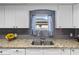 Close-up of kitchen sink area with granite countertops, white cabinets, and a window view at 2912 W Frierson W Ave, Tampa, FL 33614