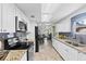 Modern kitchen featuring white cabinets, granite countertops, stainless steel appliances, and tiled floors at 2912 W Frierson W Ave, Tampa, FL 33614