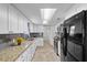 Well-lit kitchen with white cabinets, stainless steel appliances, and granite countertops at 2912 W Frierson W Ave, Tampa, FL 33614
