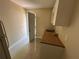 Small kitchenette featuring tiled floors, a stainless sink, minimalist cabinetry, and an exterior door at 1912 W Clinton St, Tampa, FL 33604