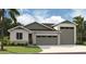 Attractive single-story home featuring a well-manicured lawn, stone accents, and a two-car garage at 9177 Players Dr, Weeki Wachee, FL 34613