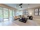 Spacious living room with ample seating, neutral tones, and sliding glass doors to lanai at 9177 Players Dr, Weeki Wachee, FL 34613