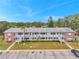 Two-story apartment complex featuring brick accents, palm trees, and exterior staircases under a bright blue sky at 2353 Shelley St # 10, Clearwater, FL 33765