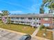 Two-story apartment building with lush green grass, parking and classic exterior stairs at 2353 Shelley St # 18, Clearwater, FL 33765