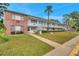 Low-angle shot of multi-story building with brick and white facade, sidewalks, and a palm tree in front at 2353 Shelley St # 18, Clearwater, FL 33765