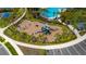 Aerial view of the community playground in a neighborhood with palm trees and parking at 3884 Capri Coast Dr, Plant City, FL 33565
