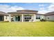 Back exterior showcasing a covered patio, ample yard space and sliding glass doors at 3884 Capri Coast Dr, Plant City, FL 33565