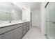 Bright bathroom featuring double sinks, sleek vanity, large mirror and walk-in shower at 3884 Capri Coast Dr, Plant City, FL 33565