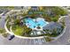Aerial view of the community pool area with palm trees, playground, and clubhouse at 3884 Capri Coast Dr, Plant City, FL 33565