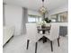 Bright dining area featuring modern lighting, a round table with white chairs, and views to the backyard at 3884 Capri Coast Dr, Plant City, FL 33565