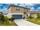 Two-story home with manicured lawn, blue garage door, and a driveway leading to the entrance at 3884 Capri Coast Dr, Plant City, FL 33565
