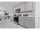 Modern kitchen featuring gray cabinets, stainless steel appliances, white countertops, and an elegant backsplash at 3884 Capri Coast Dr, Plant City, FL 33565