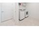 Functional laundry room with modern washer, dryer, tile flooring, and clean white walls at 3884 Capri Coast Dr, Plant City, FL 33565