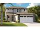 Charming two-story home showcasing a neutral palette, gray siding, stone accents, and lush landscaping at 6008 Jensen View Ave, Apollo Beach, FL 33572