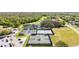 Aerial view of tennis courts with lush landscaping, pond, and a view of the golf course and surrounding neighborhood at 1025 Royal Troon Ct, Tarpon Springs, FL 34688