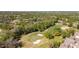 An aerial view displays the expansive golf course near surrounding homes and trees at 1025 Royal Troon Ct, Tarpon Springs, FL 34688