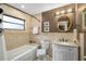 Bathroom with a bathtub, a warm color scheme, a decorative mirror and a granite countertop at 1025 Royal Troon Ct, Tarpon Springs, FL 34688