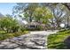 Welcoming gated community entrance with lush landscaping and mature trees at 1025 Royal Troon Ct, Tarpon Springs, FL 34688