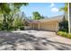 Spacious three car garage and driveway surrounded by lush trees and landscaping at 1025 Royal Troon Ct, Tarpon Springs, FL 34688