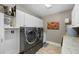 Well-organized laundry room features granite counters, upper cabinets, and modern washer and dryer at 1025 Royal Troon Ct, Tarpon Springs, FL 34688