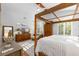 Spacious main bedroom with a four poster bed, shutters and natural light from the adjacent trees at 1025 Royal Troon Ct, Tarpon Springs, FL 34688