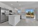Modern kitchen featuring stainless steel appliances, white cabinets, island, and sliding glass doors to the backyard at 488 Sunset N Rd, Rotonda West, FL 33947