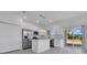 Bright kitchen featuring stainless steel appliances, white cabinets, island, and sliding glass doors to the backyard at 488 Sunset N Rd, Rotonda West, FL 33947