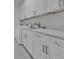 Bright laundry room with white cabinets, modern hardware, sink and stainless steel faucet at 488 Sunset N Rd, Rotonda West, FL 33947