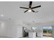 Open floor plan featuring a ceiling fan, large windows, and a kitchen with white cabinets and stainless appliances at 488 Sunset N Rd, Rotonda West, FL 33947