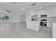 Open-concept living space featuring white cabinets, stainless steel appliances, tile floors, and natural light at 488 Sunset N Rd, Rotonda West, FL 33947