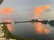 Calm waterfront view with lush green islands reflecting pink and orange clouds at 6009 Sea Ranch Dr # 101, Hudson, FL 34667