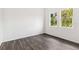 Bright bedroom with dark wood-look flooring and natural light from two windows at 4160 Belladonna Ave, North Port, FL 34286