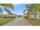 Long driveway leading to a spacious home, enhanced by lush landscaping and mature palm trees at 18011 Prairie Wolf Gln, Parrish, FL 34219