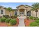 Charming front exterior featuring a well-manicured lawn, mature palm trees, and a welcoming entrance at 18011 Prairie Wolf Gln, Parrish, FL 34219