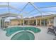 Backyard with relaxing screened-in pool and spa, surrounded by a spacious patio for entertaining at 18011 Prairie Wolf Gln, Parrish, FL 34219
