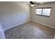 This empty bedroom has light gray walls, tile flooring, and a ceiling fan at 1961 Whitney Way, Clearwater, FL 33760