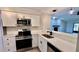 Well-lit kitchen showcases stainless steel appliances and white countertops at 1961 Whitney Way, Clearwater, FL 33760